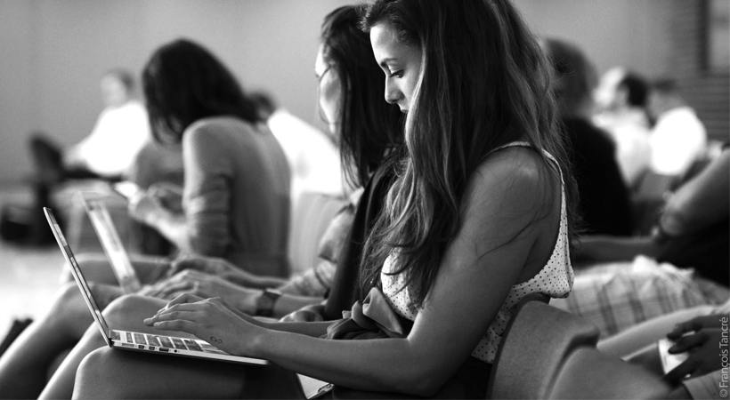 Photo noir et blanc de Laura Calmore assise en train de taper sur un ordinateur